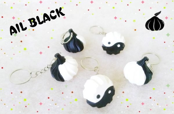 Porte-clés noir en forme de bulbe d'ail, noir et blanc comme le symbole du yin yang formant la base.